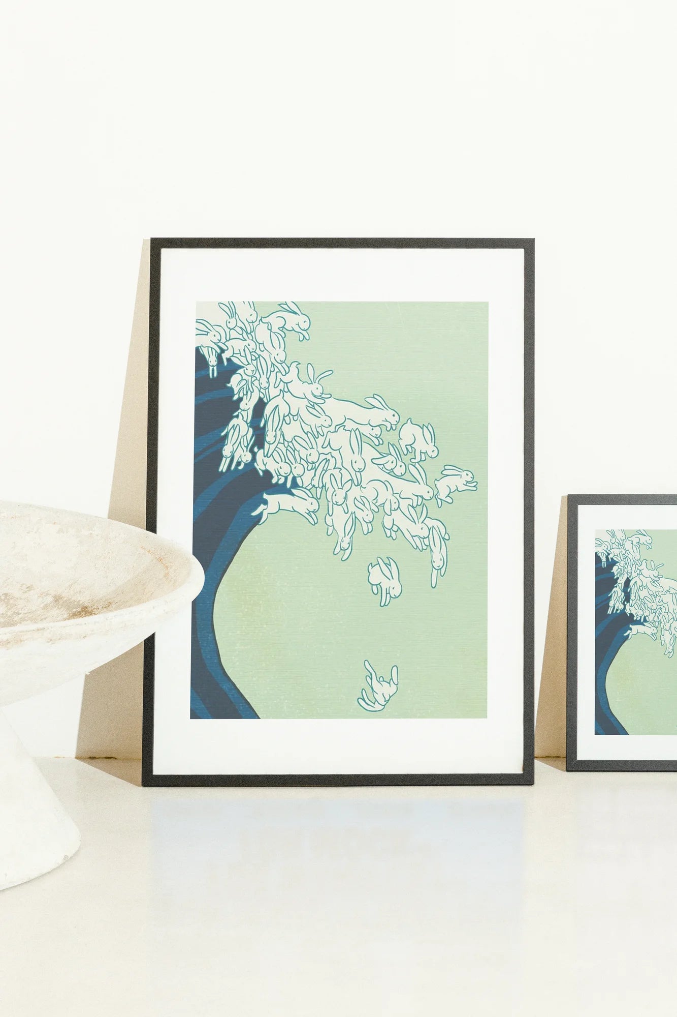 Œuvre d'art minimaliste représentant des lapins blancs interagissant avec une forme d'onde fluide sur un fond serein allant du vert clair au bleu profond.. blue, ink, line art, minimalist, white