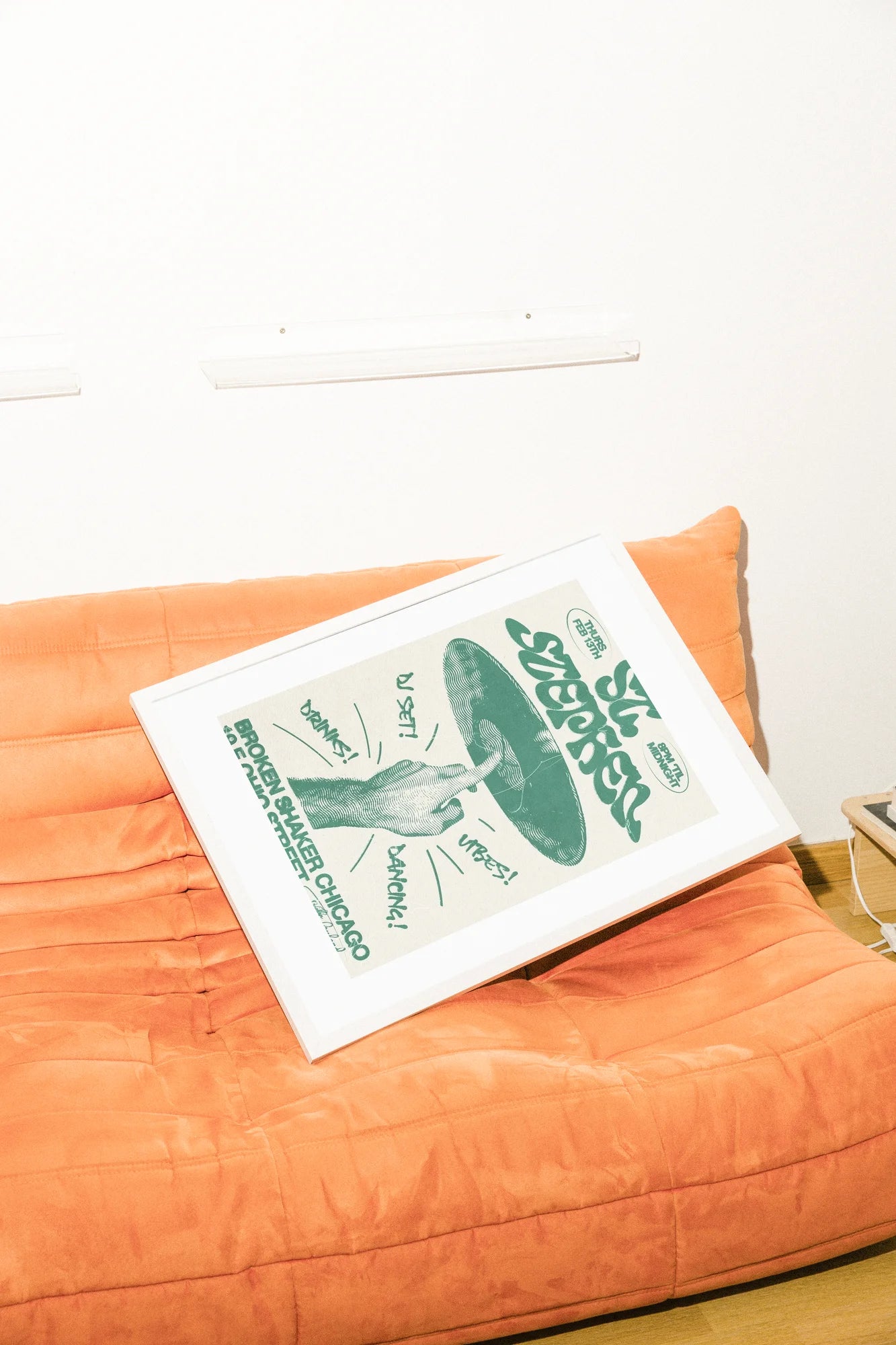 Une encre audacieuse rencontre un vert vibrant sur un blanc cassé, capturant un flyer rétro-festif où une main repose sur son propre chapeau. Une typographie dynamique pulse d'un rythme énergique.. black, green, illustration, retro, typographic, white