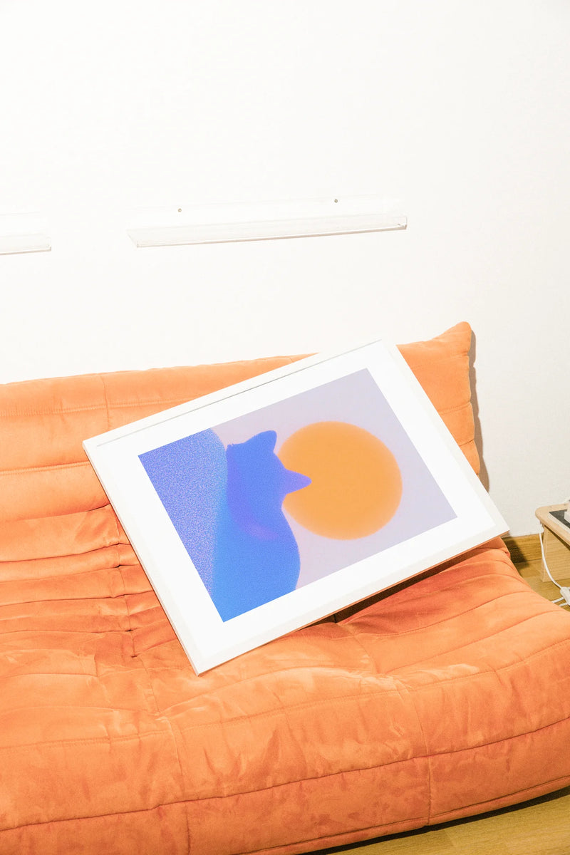 Une illustration numérique minimaliste présente une silhouette de chat bleu fantomatique sur un fond bleu texturé, baignée de lumière par un soleil orange éclatant.. blue, digital, minimalist, orange, serene