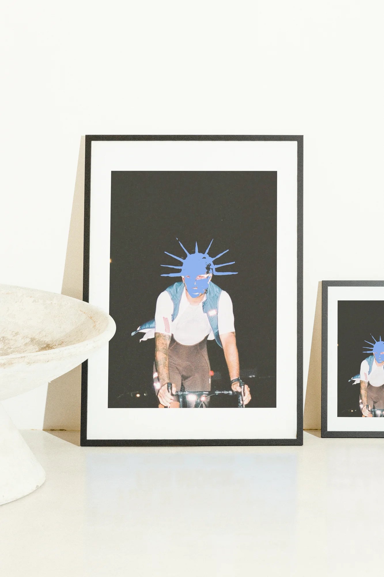 Une silhouette saisissante de cycliste sur un vide sombre. Un couvre-chef bleu vif et pointu contraste fortement avec la nuit et les ombres, capturant la forme, le mouvement et l'audace.. blue, dark, edgy, graphic overlay, mysterious, white