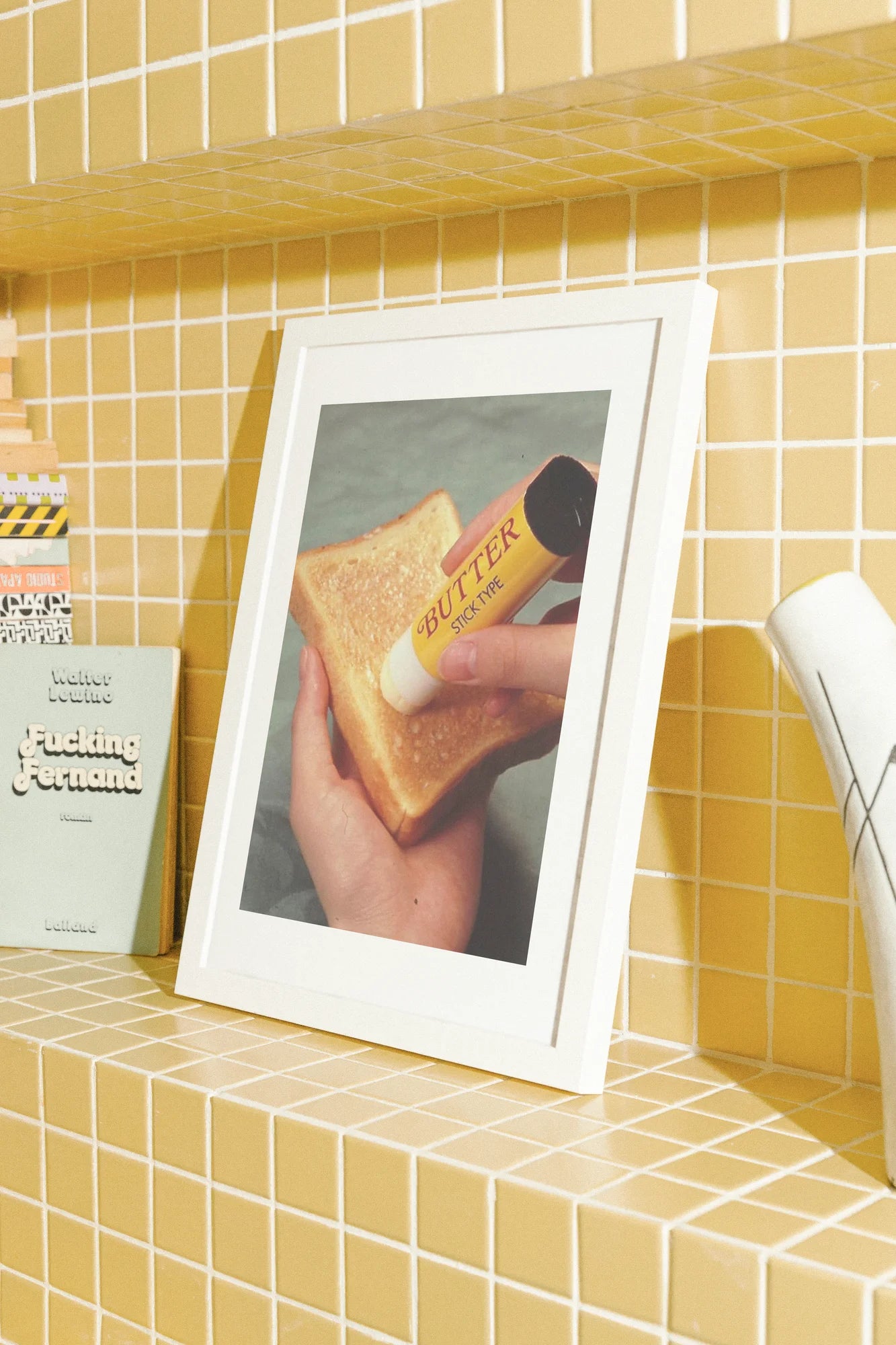 Une capture photoréaliste où la chaleur rencontre la fantaisie. Une main appose une étiquette jaune sur du pain grillé, capturant la joie tranquille du petit-déjeuner sous son jour le plus simple.. brown, orange, photographic, still life, warm, yellow