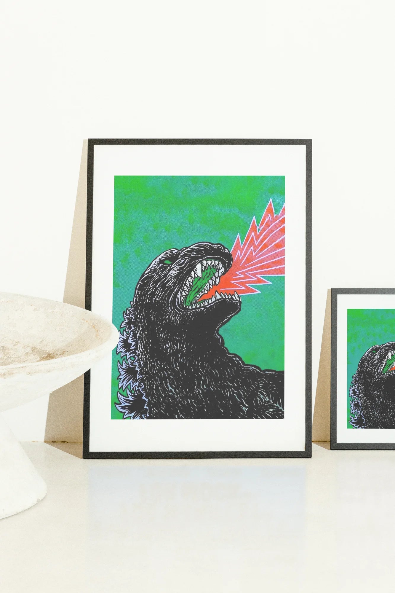 Godzilla stylisé monochrome sur une étendue verte vibrante, capturant une explosion sonore intense. Des lignes graphiques audacieuses définissent la gueule explosive et l'énergie rouge ardente.. black, dark, digital, green, line art