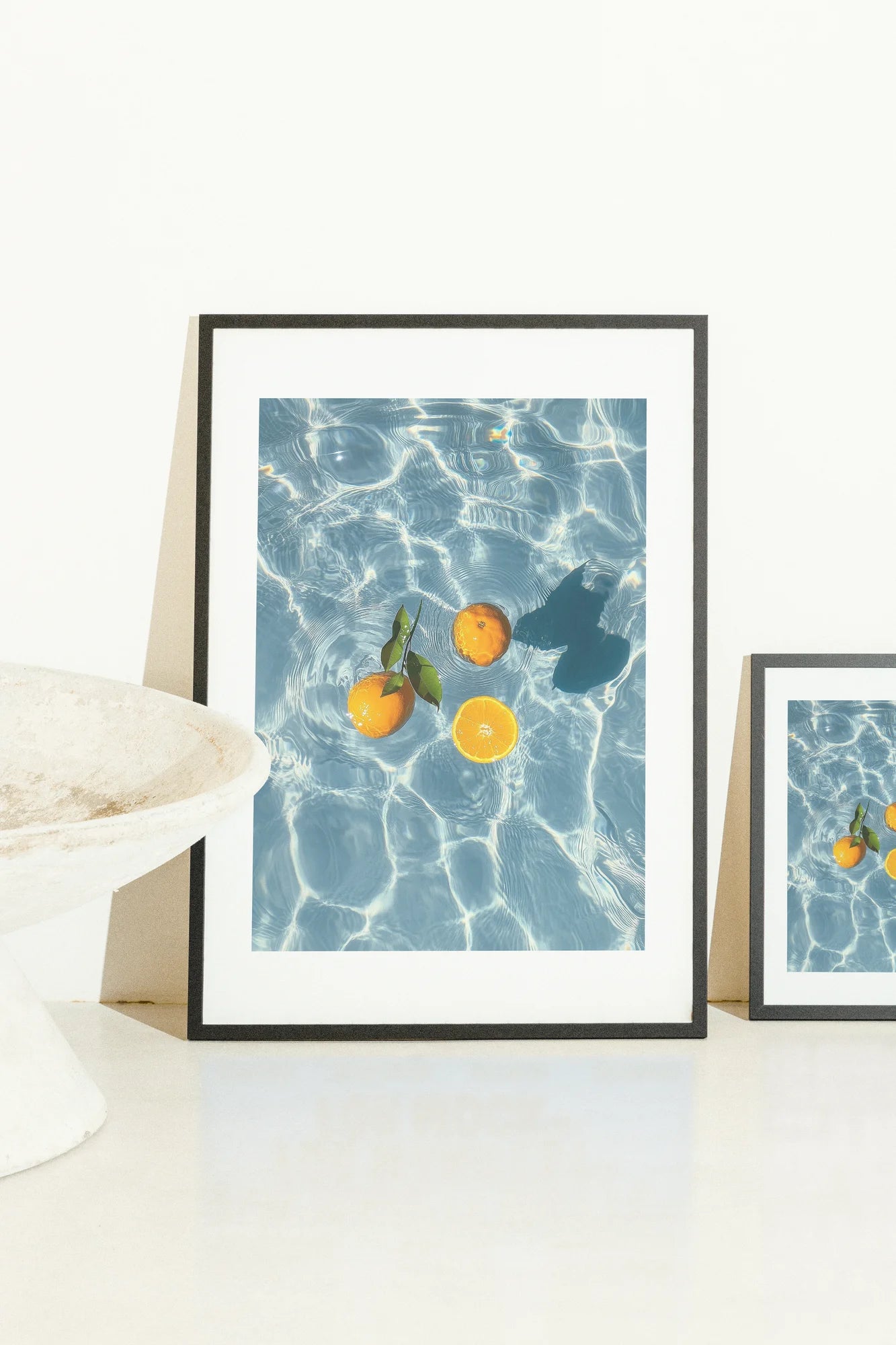 Capture photoréaliste d'oranges flottantes sur une eau bleue ondulante, où des feuilles verdoyantes dansent aux côtés de tons d'agrumes pour évoquer une fraîcheur sereine.. blue, botanical, orange, photography, serene
