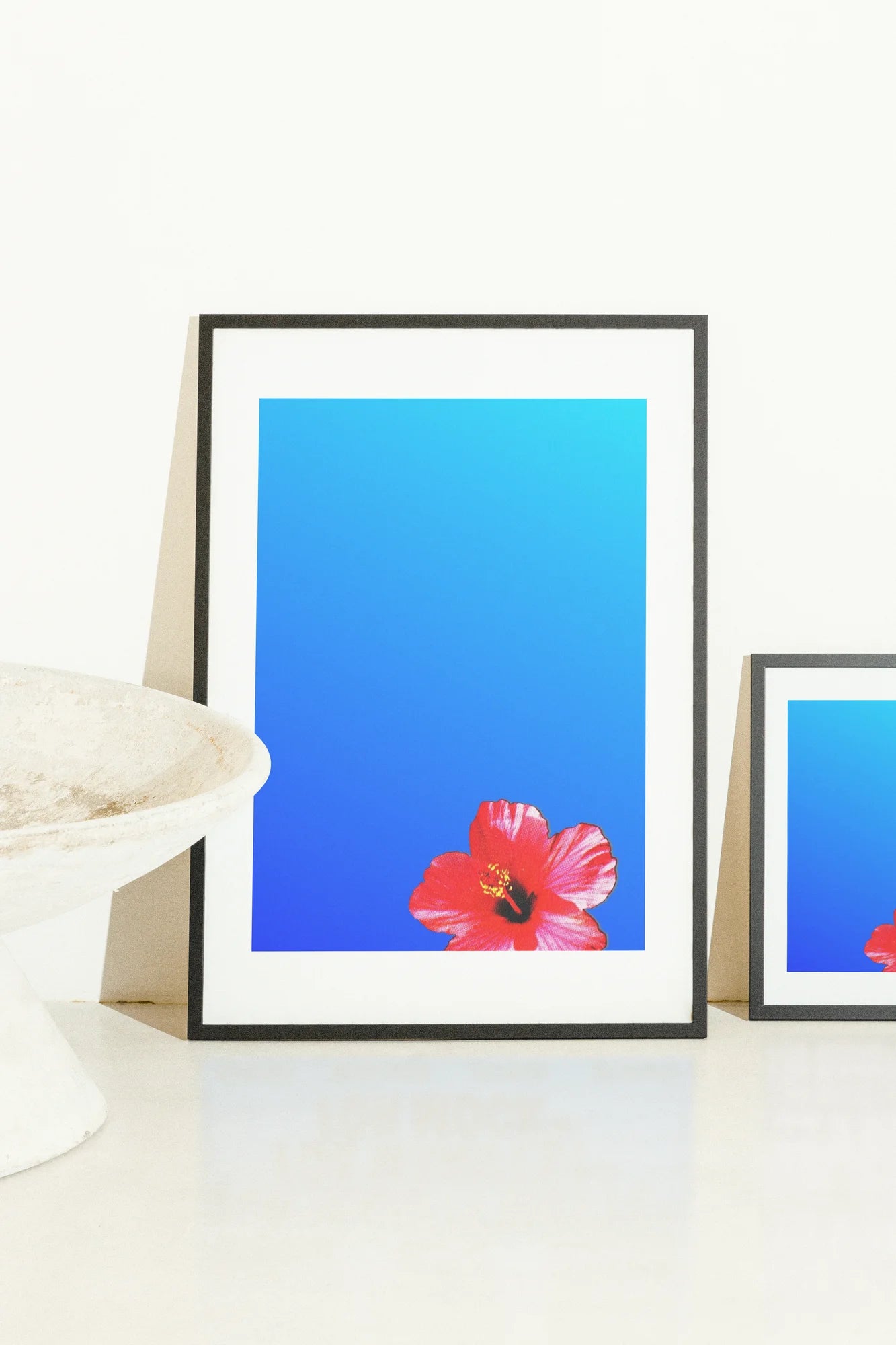 Un hibiscus rouge vibrant s'épanouit audacieusement sur un dégradé de bleu serein, capturant un moment exaltant de l'énergie pure de la nature.. blue, digital, minimalist, red, vibrant