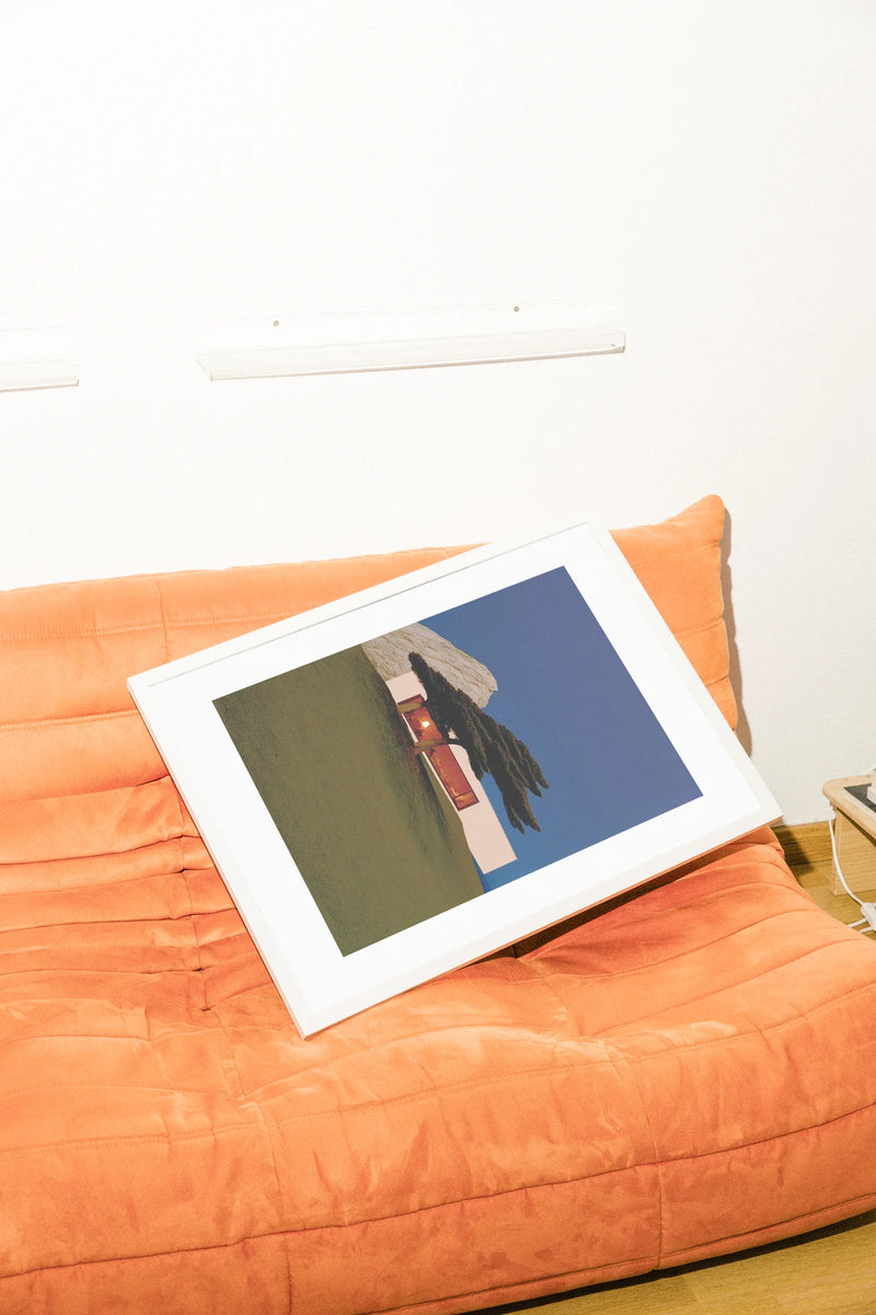 Une maison minimaliste nichée sur une pente douce, illuminée par des lumières chaudes sur un ciel bleu frais et encadrée par un pin proéminent. Une tranquillité sereine dans l'art moderne.. blue, minimalist, modern, orange, photographic, serene