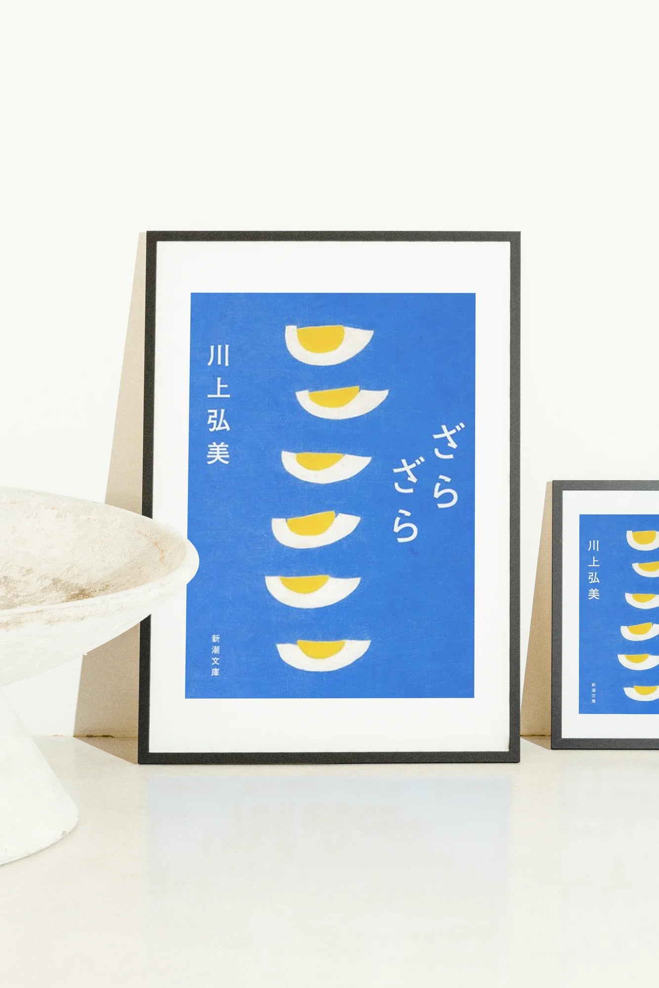 Toile bleue minimaliste présentant des moitiés d'œufs stylisées disposées verticalement avec des accents audacieux blancs et jaunes. Un design serein et plat évoquant une géométrie tranquille et un calme intemporel.. blue, digital art, geometric, minimalist, white, yellow