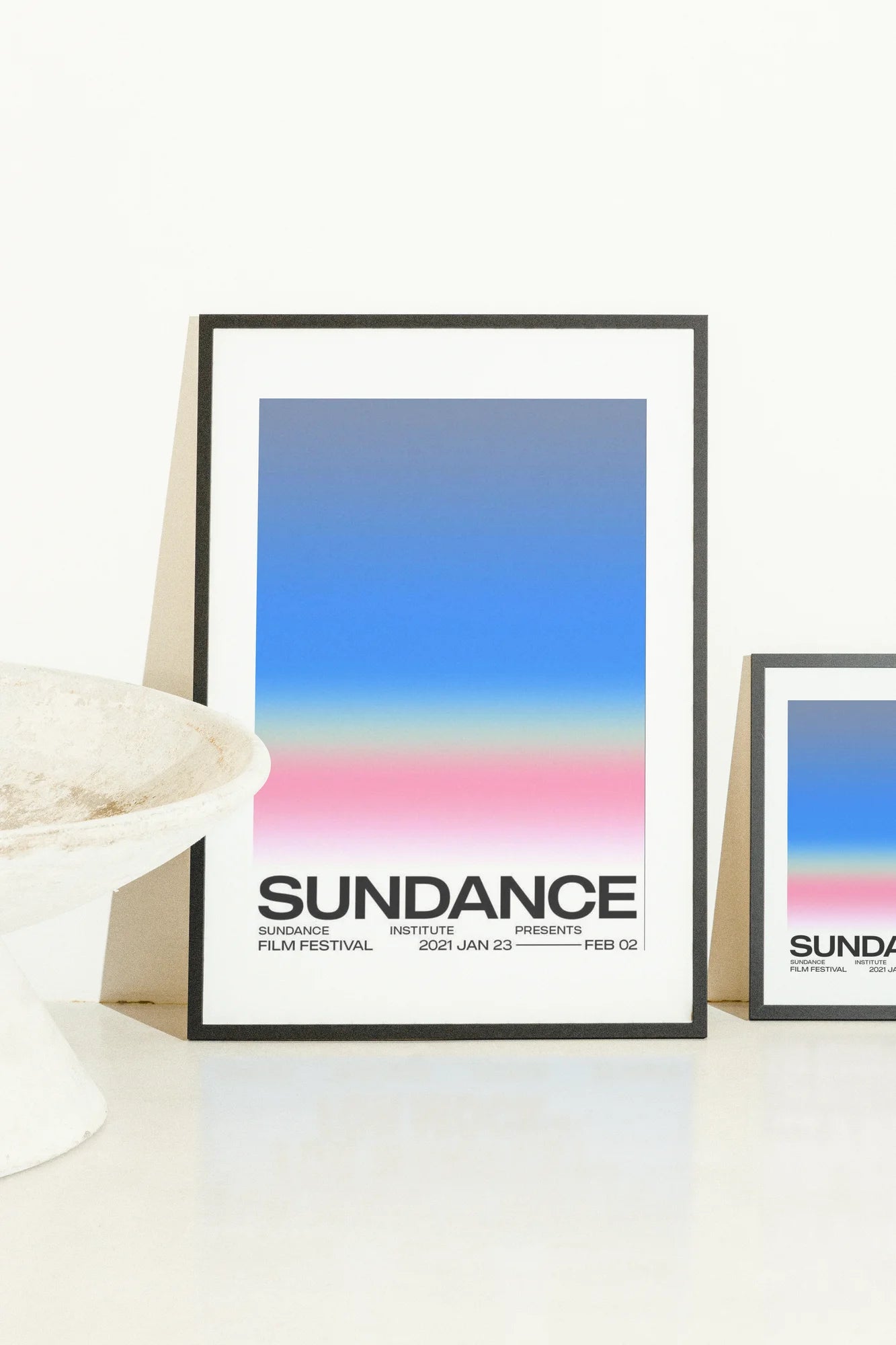 Un dégradé doux passe du bleu océan profond au rose poudré, sur une typographie noire audacieuse pour Sundance 2024. La composition minimaliste évoque le cœur émotionnel du cinéma moderne.. blue, minimalist, modern, pink, typographic
