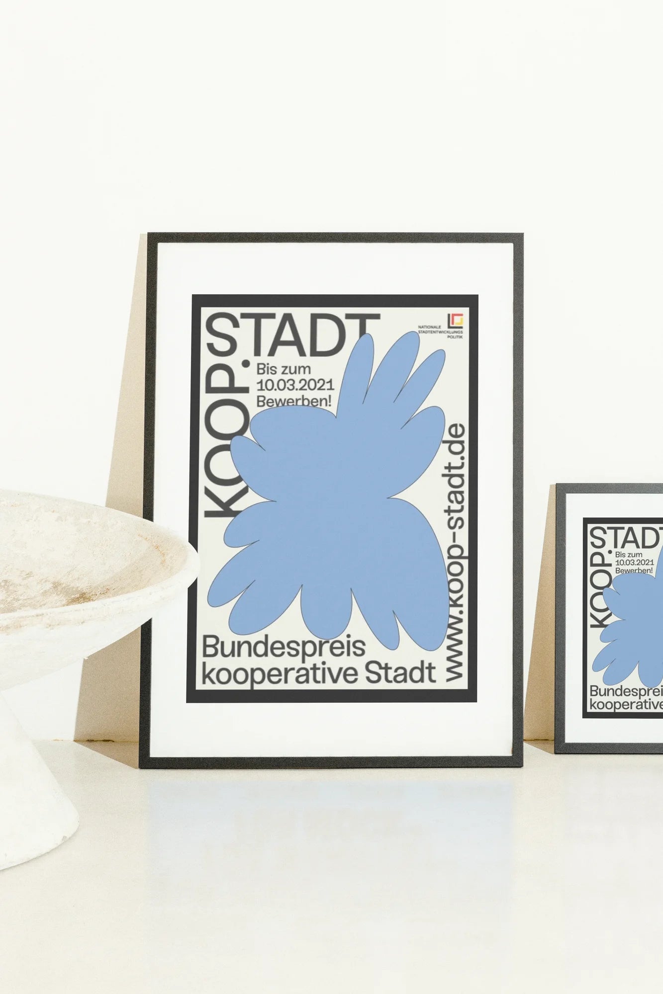 Affiche d'illustration numérique présentant des formes bleues abstraites et une typographie audacieuse sur un fond noir et blanc saisissant, invitant à la soumission pour le Bundespreis kooperative Stadt.. blue, digital, minimalist, typographic, white